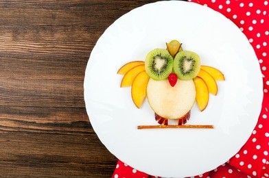 funny fruits owl for kids breakfast on wooden background. healthy snacks. top view