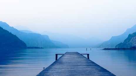 panorama of mountain lake at sunset. mountain range in the background. wooden pier.
