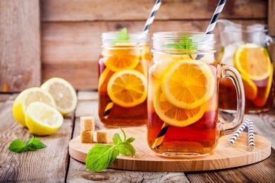 ice tea with slice of lemon in mason jar on the wooden rustic background