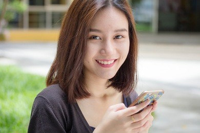 portrait of thai adult student university beautiful girl calling smart phone