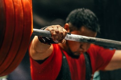 male powerlifter preparing for squats with a barbell during competition of powerlifting