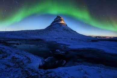 the beautiful green and red aurora dancing over the kirkjufell mountain with at winter, nightlight,iceland
