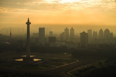 the sun rising in national monument of indonesia located in jakarta