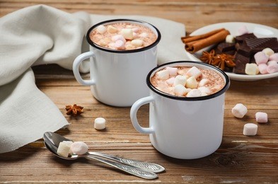 hot chocolate with marshmallows and spices on rustic wooden table, selective focus