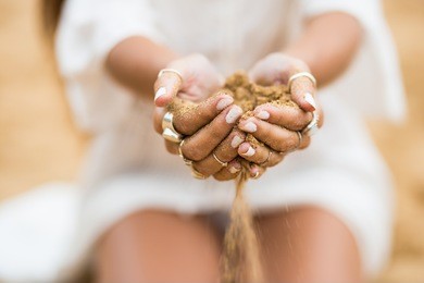 girl playing sand in her hands in the beach