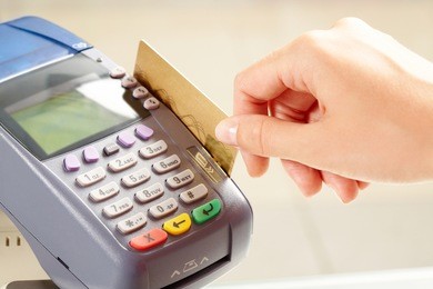 close-up of payment machine buttons with human hand holding plastic card near by