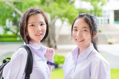 cute asian thai high schoolgirls student couple in school uniform standing with her friend in a happy smile face expression