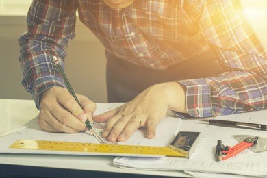 architect drawing on architectural projecting with pencil on the urban drawings. home planning,architectural construction plans, pencil and ruler on the desk,selective focus,vintage color