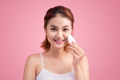beauty face of young woman with cosmetic cream on a cheek. skin care concept. closeup portrait isolated on white.