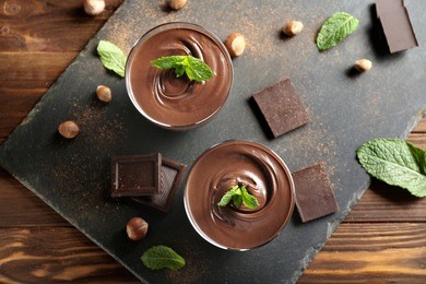 chocolate mousse with mint in portion glasses on slate cheese board