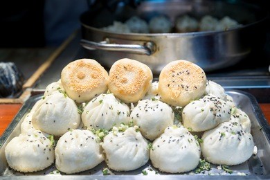 fried chinese pork bun in food market, shanghai, china. tradition shanghai chinese food.