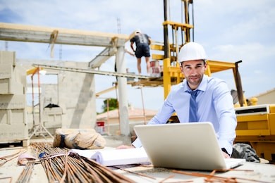 portrait of handsome young man architect on a building industry construction site