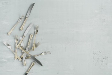 flat lay of golden fork and knife on grey concrete background. top view