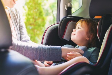 toddler girl buckled into her car seat