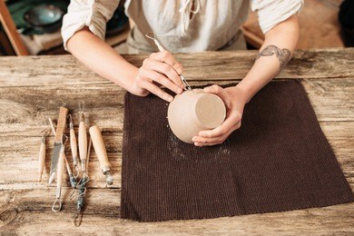 clay bowl author decorating, pottery making. carving of handmade crockery with special tools