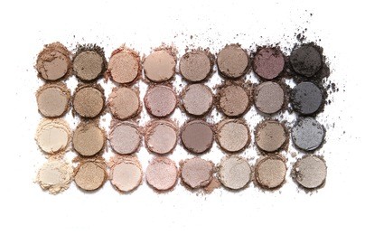 a broken neutral colored eye shadow make up palette isolated on a white background