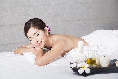 young asian woman on massage table in beauty spa salon,beautiful young female relaxing in spa.
