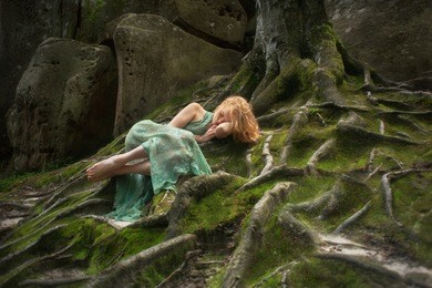 freckles, red-haired woman in fairy forest on the moss