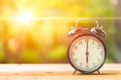 retro 6 o'clock and morning sun with bright and flare day light blur green garden background with space for text.
