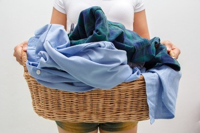 woman holding a laundry basket full of clothes