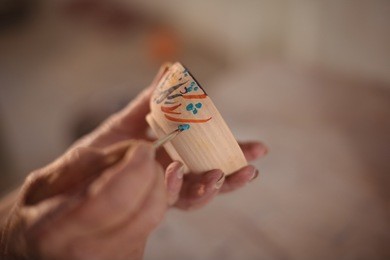 close-up of potter painting on bowl in pottery workshop