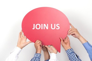 group of people holding the join us written speech bubble