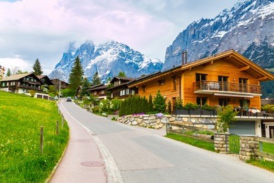 grindelwald valley with village scattered on the green slopes of bernese alps. grindelwald village in switzerland is a popular gateway for skiing in winter and hiking in summer.