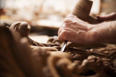 hands of craftsman carve  with a gouge in the hands on the workbench in carpentry
