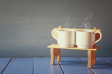 couple coffee cups on old bench. vintage filtered. romance and weekend concept

