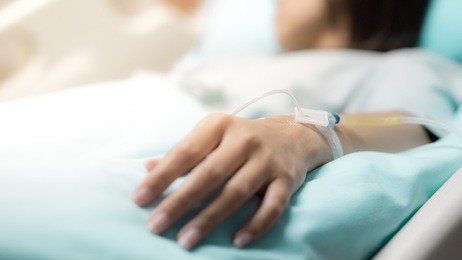 hospital and patient concept -  asian patient woman sleep in bed with iv solution on her hand in room of hospital