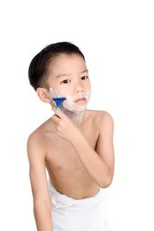 young boy is shaving his face in the bathroom.