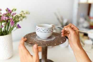 pottery. painting pottery. the girl draws on a clay bowl. life style. concept. she works in her studio
