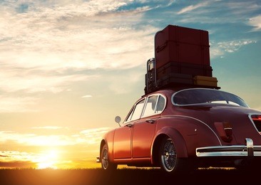 retro red car with luggage on roof rack at sunset. travel, vacation concepts. 3d illustration