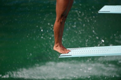 sportsman diving in olympic swimming pool from a high-board
