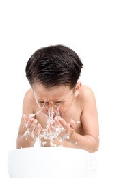 young boy wash his face by fresh water in white bathroom.