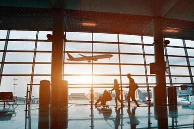 people in airport, silhouette of young family with baby traveling by plane, vacations