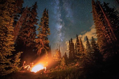 family stargazing by a campfire, colorado rockies, usa.