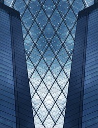 glass architecture. part of structural glass facade and fragments of two lateral towers. digitally altered photo of hi-tech building fragment.