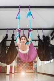 young woman posing doing aerial yoga exercise. 