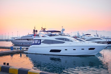 extra large luxury yachts rest in the port at sunset