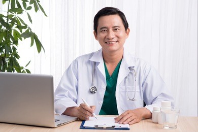 doctor working at table in office