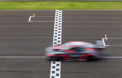 race car crossing the finish line on a circuit