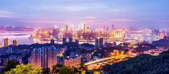cityscape and skyline of downtown near water of chongqing at night