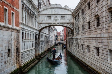 gondolas floating on canal towards bridge of sighs (ponte dei sospiri) venice , italy