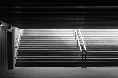 underground passage walk. exit to the city. way out. abstract black-and-white architecture photograph with back light.