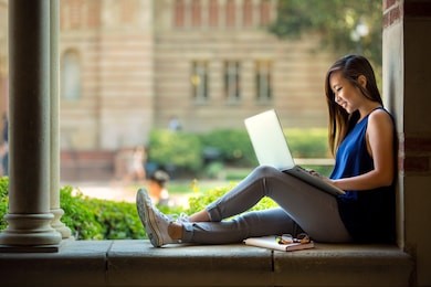 college student studying on campus outdoor with laptop casual lifestyle