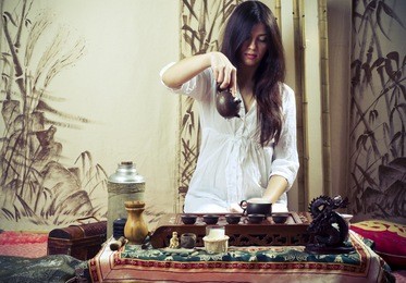 a young girl holds a chinese tea ceremony