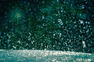 rain drops splashing on a table in the garden rainy day background