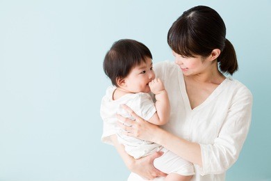 portrait of asian mother and baby isolated on blue background
