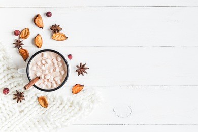 autumn composition. hot chocolate, knitted blanket and autumn leaves. flat lay, top view.